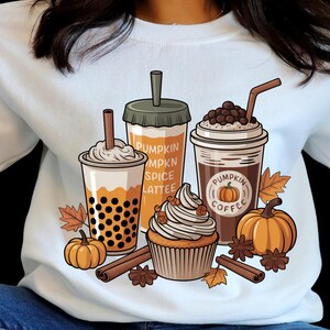Peut inclure: Sweat-shirt blanc avec un motif sur le thème de l'automne. Le motif comprend trois boissons au café, un cupcake, des citrouilles, des bâtons de cannelle et le texte "Pumpkin Spice Latte" et "Pumpkin Coffee".