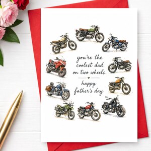 Pode incluir: Um cartão de Dia dos Pais com ilustrações em aquarela de várias motocicletas. O cartão diz "you're the coolest dad on two wheels. happy father's day" em escrita preta. O cartão está em um envelope vermelho.