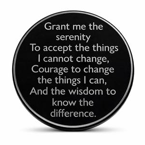 May include: A black, round token with a silver border. The text "Grant me the serenity to accept the things I cannot change, Courage to change the things I can, And the wisdom to know the difference" is inscribed in silver lettering.
