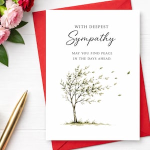 May include: A white sympathy card featuring a watercolor illustration of a tree with leaves blowing in the wind. The text reads: WITH DEEPEST SYMPATHY, MAY YOU FIND PEACE IN THE DAYS AHEAD. The card is placed on a red envelope next to a gold pen.