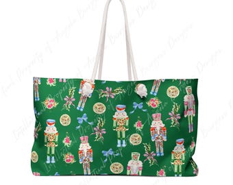 May include: A green tote bag featuring a repeating pattern of nutcracker figures, floral bouquets, and blue bows. The bag has two white rope handles attached to the top. The design includes various nutcrackers in different poses and colors.