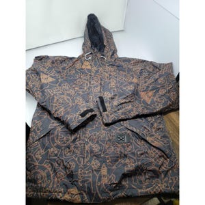 May include: A hooded jacket with a black and brown pattern. The jacket has a black interior, a drawstring hood, and a front zipper closure. The sleeves have adjustable cuffs with velcro closures. The jacket has a unique, all-over design.