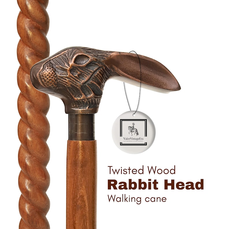 May include: A wooden walking cane with a twisted shaft and a rabbit head handle. The rabbit head is bronze-colored and detailed. The cane has a tag with a logo and the text "Twisted Wood Rabbit Head Walking cane".