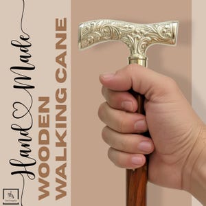 K&ouml;nnte beinhalten: Handgefertigter Holz-Spazierstock. Der Stock hat einen dekorativen, silberfarbenen Griff mit einem verzierten floralen Design. Der Holzschaft ist dunkelbraun. Der Text "Hand Made Wooden Walking Cane" ist im Bild zu sehen.