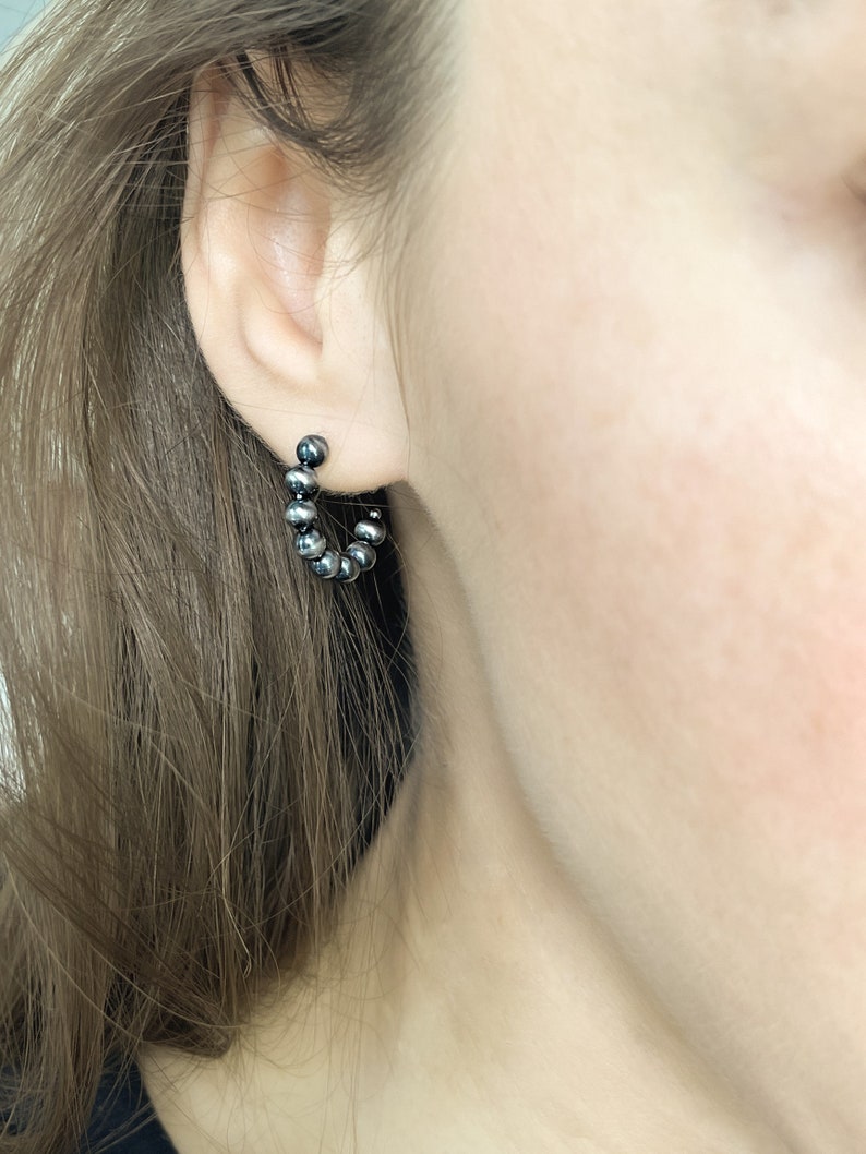 Dark Sterling silver Open hoop earrings, ball hoop earrings on a female model inspired by Navajo Pearls