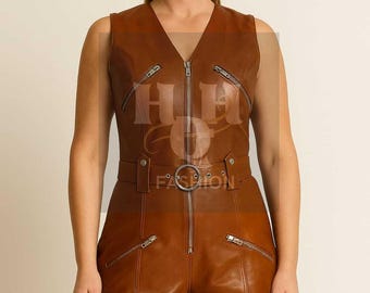 May include: A sleeveless brown leather romper with a V-neckline and a front zipper. The romper features multiple zippered pockets and a belt with a silver-colored buckle. The shorts are short-length.