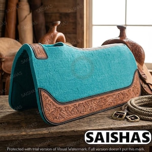 May include: A turquoise felt saddle pad featuring tan leather trim with intricate floral tooling along the bottom edges and corners. The pad has a contoured shape and is accented with dark brown leather piping, showcasing detailed craftsmanship.