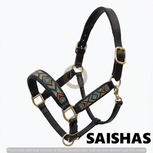 May include: A black leather horse headcollar featuring brass-toned metal hardware and buckles. The noseband and cheek pieces are decorated with a geometric pattern of small turquoise, brown, and cream-coloured beads. The word SAISHAS is visible.