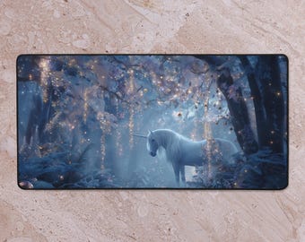 May include: A rectangular mousepad depicting a fantasy scene with a white unicorn in a forest. The artwork has a blue and white colour scheme with sparkling lights, creating a magical atmosphere. The unicorn stands near a tree.