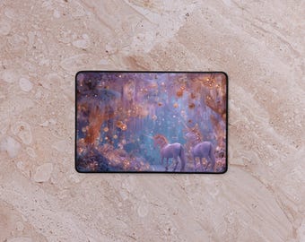 May include: Rectangular mouse mat depicting a fantasy scene with two unicorns in a mystical forest. The artwork uses blues, purples, and golds, creating a soft, dreamlike effect. The unicorns are white with golden manes.