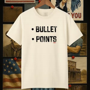 May include: Cream-colored t-shirt with the words "BULLET POINTS" in black, with a small red "TOT" below "POINTS". The shirt hangs on a wooden hanger against a backdrop of Americana-themed artwork.