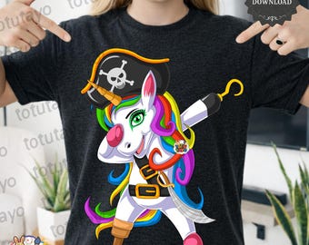 May include: Dark gray t-shirt featuring a cartoon unicorn dressed as a pirate. The unicorn has a rainbow mane and tail, a pirate hat with a skull, a hook, and a sword. The text "Totu Tayo" and "PNG" are also visible.
