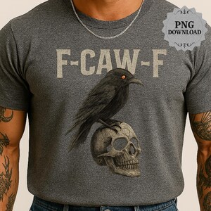 May include: A gray t-shirt with the text "F-CAW-F" in a light tan color. A black crow with orange eyes is perched on a skull. The design is a graphic illustration.