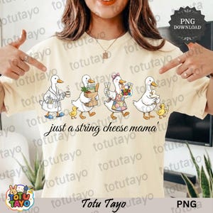 May include: A cream-coloured t-shirt with a cartoon illustration of four geese, each with different items. The geese are accompanied by ducklings. The text "just a string cheese mama" is below the geese.