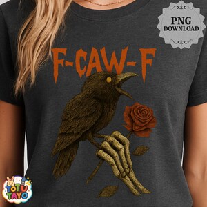 May include: Dark gray t-shirt featuring a crow illustration with the text "F-CAW-F". The crow is holding a rose in a skeletal hand. The design has orange and brown tones.
