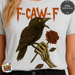 May include: A light gray t-shirt featuring a detailed illustration of a crow perched on a branch, holding a rose. The crow has yellow eyes and is set against the text "F-CAW-F" in orange. The design includes a skeleton hand holding the rose.
