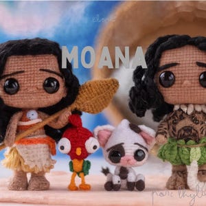 Op de afbeelding: Gehaakte poppen van de personages Moana en Maui, samen met Hei Hei en Pua. Moana-pop draagt een oranje en witte outfit en houdt een peddel vast. Maui-pop heeft een groene rok en een haak. Hei Hei is rood en geel. Pua is wit en roze.