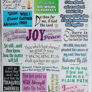 May include: A sheet of stickers with various Bible verses in different fonts and colors. The stickers include phrases like "He is the Rock," "Joy," and "Treasures of Darkness." The stickers are designed for use in journals or crafts.