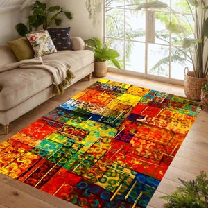 May include: A colourful rectangular rug with an abstract design. The rug has a patchwork of blocks in red, yellow, blue, and green. It's placed on a wooden floor in a living room setting, with a sofa and plants visible.