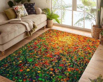 May include: A rectangular area rug with a vibrant abstract design. The rug features a blend of colors, including green, orange, yellow, and red, creating a lively and artistic pattern. The rug is placed on a wooden floor.
