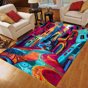May include: A vibrant, abstract area rug with a colorful cityscape design. The rug features a mix of blues, pinks, oranges, and purples, creating a bold and artistic statement. The design includes architectural elements and flowing patterns.