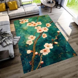 Könnte beinhalten: Ein rechteckiger Teppich mit floralem Design. Der Teppich hat einen türkis- und türkisblauen Hintergrund mit einem Zweig aus rosa und weißen Kirschblüten. Der Teppich liegt auf einem Holzboden in einem Wohnzimmer.