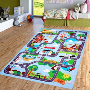 Op de afbeelding: Een rechthoekig speelkleed voor kinderen met een wegenkaartontwerp. Het kleed heeft wegen, gebouwen, een schoolbus, politieauto's, een dierentuin en een park, alles tegen een lichtblauwe achtergrond. Het ontwerp bevat kleurrijke illustraties en tekst.