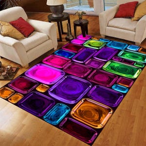 May include: A rectangular area rug with a vibrant, colorful design. The rug features a pattern of glossy, rectangular shapes in shades of pink, purple, blue, green, and orange, set against a black background. The rug is placed on a wooden floor.