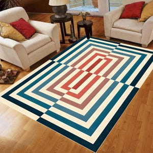 May include: A rectangular area rug featuring a geometric pattern of concentric rectangles in shades of teal, dark blue, and muted red against a cream background, creating a symmetrical design that spans the entire surface of the floor covering.
