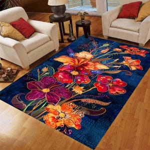 May include: A rectangular area rug with a vibrant floral design. The rug features large, stylized flowers in shades of orange, red, and purple against a deep blue background. The design includes intricate details and a textured appearance.