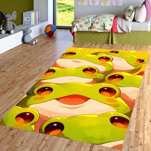 May include: A rectangular rug featuring a repeating pattern of cartoon frog faces. The frogs have large, red eyes, green skin, and smiling mouths. The rug has a yellow background and is placed on a wooden floor.