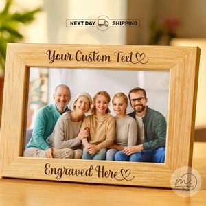 May include: A rectangular wooden photo frame with the text "Your Custom Text" and "Engraved Here". The frame holds a family portrait. The frame is made of light-colored wood.