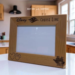 May include: A wooden picture frame with the Disney Cruise Line logo and the year 2025 engraved on it. The frame also features a Mickey Mouse and Minnie Mouse silhouette and a cruise ship design. The frame is made of light-colored wood.