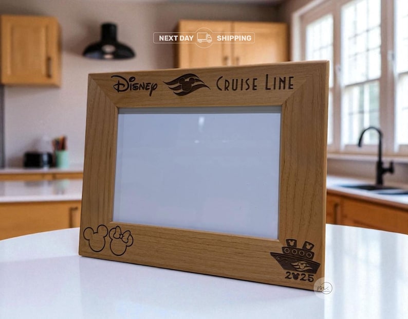 May include: A wooden picture frame with the Disney Cruise Line logo and the year 2025 engraved on it. The frame also features a Mickey Mouse and Minnie Mouse silhouette and a cruise ship design. The frame is made of light-colored wood.
