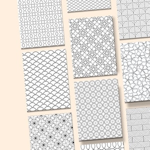 May include: A collection of black and white patterned designs, each on a rectangular card. The patterns include floral, geometric, and abstract shapes. The cards are arranged on a light beige background, showcasing the variety of designs.
