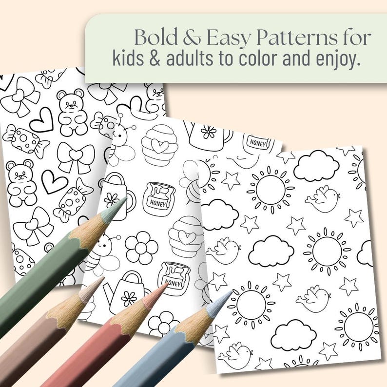 May include: Four colouring pages with black and white line drawings of various patterns, including teddy bears, bows, honey pots, and suns. The text at the top reads "Bold & Easy Patterns for kids & adults to colour and enjoy." Four coloured pencils are in the foreground.