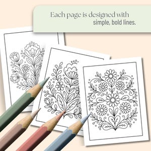 May include: Four colored pencils rest on top of three coloring pages with floral designs. The pages are black and white line drawings. The text on the top reads: Each page is designed with simple, bold lines.