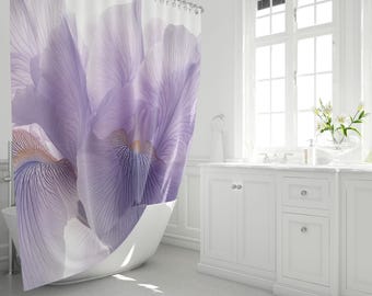 Könnte beinhalten: Duschvorhang mit Nahaufnahme einer lila Irisblüte. Der Vorhang hat einen weißen Hintergrund. Das Badezimmer hat einen weißen Waschtisch und ein großes Fenster.