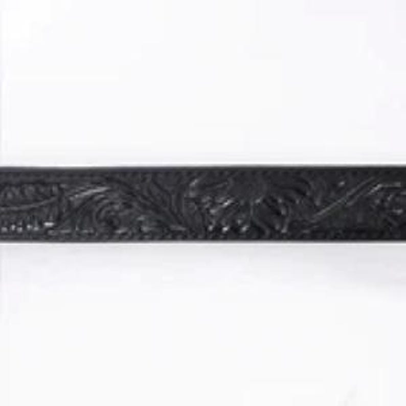 K&ouml;nnte beinhalten: Schwarzer Lederg&uuml;rtel mit aufwendiger Blumen- und Blattverzierung. Der G&uuml;rtel weist ein detailliertes gepr&auml;gtes Design entlang seiner L&auml;nge auf und zeigt einen klassischen Western-Stil. Der G&uuml;rtel ist vor wei&szlig;em Hintergrund.