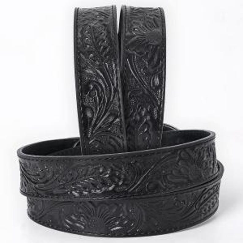 K&ouml;nnte beinhalten: Schwarzer Lederg&uuml;rtel mit floralem Pr&auml;gemuster. Der G&uuml;rtel weist ein detailliertes Muster aus Blumen und Bl&auml;ttern auf. Der G&uuml;rtel wird in gerollter Position gezeigt, wobei das gepr&auml;gte Design deutlich sichtbar ist. Der G&uuml;rtel besteht aus einem strapazierf&auml;higen Material.