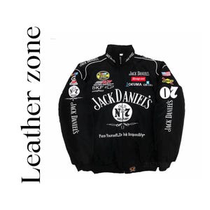Puede incluir: Chaqueta de carreras negra con el logotipo de Jack Daniel's y parches de patrocinadores. La chaqueta tiene cremallera completa, cuello alto y detalles blancos. El texto "Pace Yourself. Drink Responsibly" está impreso en la parte delantera.