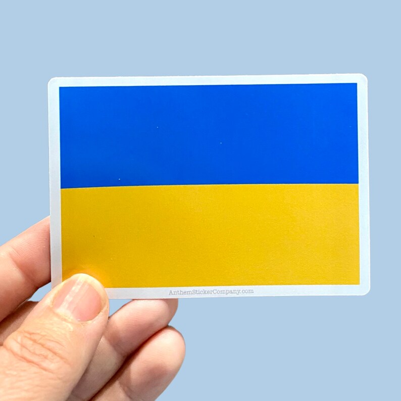 May include: A sticker featuring the Ukrainian flag. The flag is blue and yellow with a white border. The text "AnthemStickerCompany.com" is printed at the bottom of the sticker.