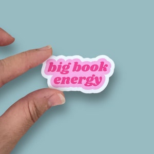 May include: Pink sticker with the text "big book energy" in a retro font.