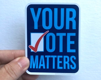 May include: A blue and white sticker with the text "YOUR VOTE MATTERS" in white letters on a blue background. A red checkmark is in a white box next to the word "VOTE".