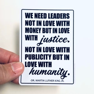 May include: Black and white text on a white background with a quote by Dr. Martin Luther King Jr. that reads: "We need leaders not in love with money but in love with justice. Not in love with publicity but in love with humanity."