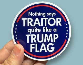 May include: A round blue and red sticker with white text that says "Nothing says TRAITOR quite like a TRUMP FLAG".