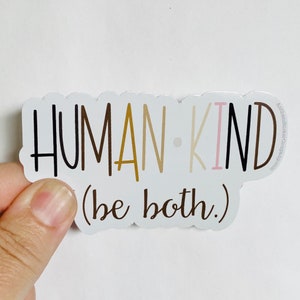 May include: White sticker with the words "HUMAN-KIND (be both)" in black, brown, gold, and pink lettering.