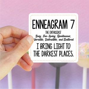 May include: White sticker with black text that reads "ENNEAGRAM 7 THE ENTHUSIAST Busy, Fun-Loving, Spontaneous, Versatile, Distractible, and Scattered I BRING LIGHT TO THE DARKEST PLACES. Atham@tickerCompany.com"