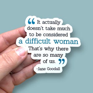 May include: A blue and white sticker with a quote by Jane Goodall: "It actually doesn't take much to be considered a difficult woman. That's why there are so many of us."