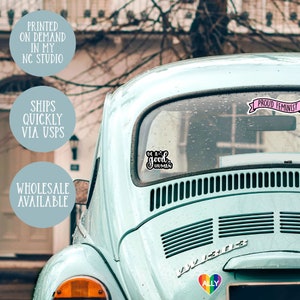 May include: A blue Volkswagen Beetle with several stickers on the back window. The stickers say "Be a good human", "Proud Feminist", and "Ally".